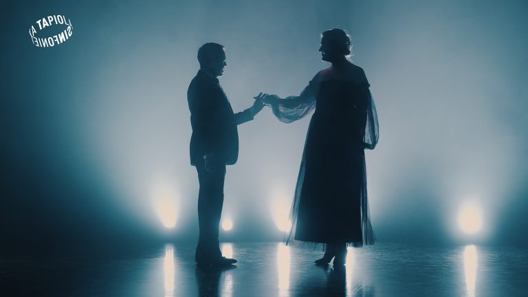 Otetta ottava tanssipari näkyy siluetteina valoa vasten.