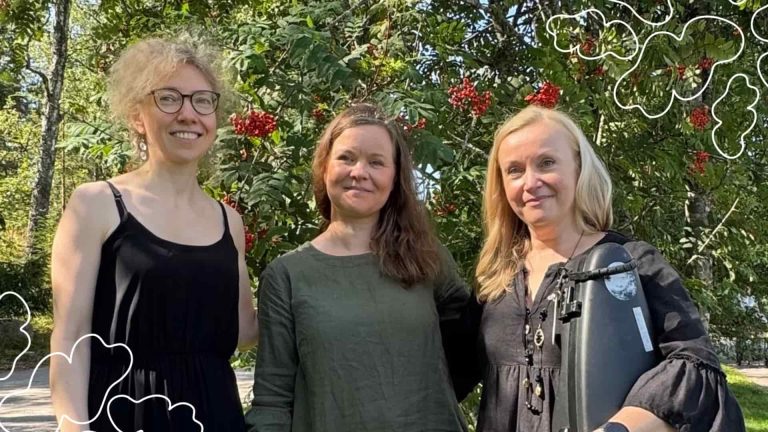 Kolme konsertin esiintyjää seisoo rivissä ja katsoo hymyillen kameraan.