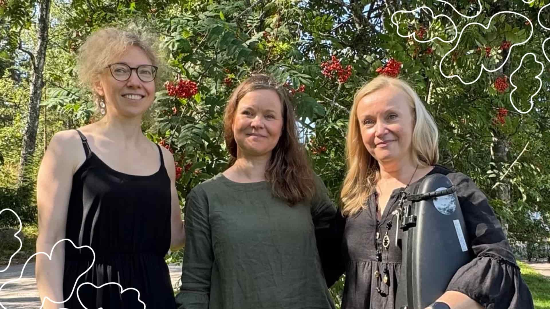 Kolme konsertin esiintyjää seisoo rivissä ja katsoo hymyillen kameraan.