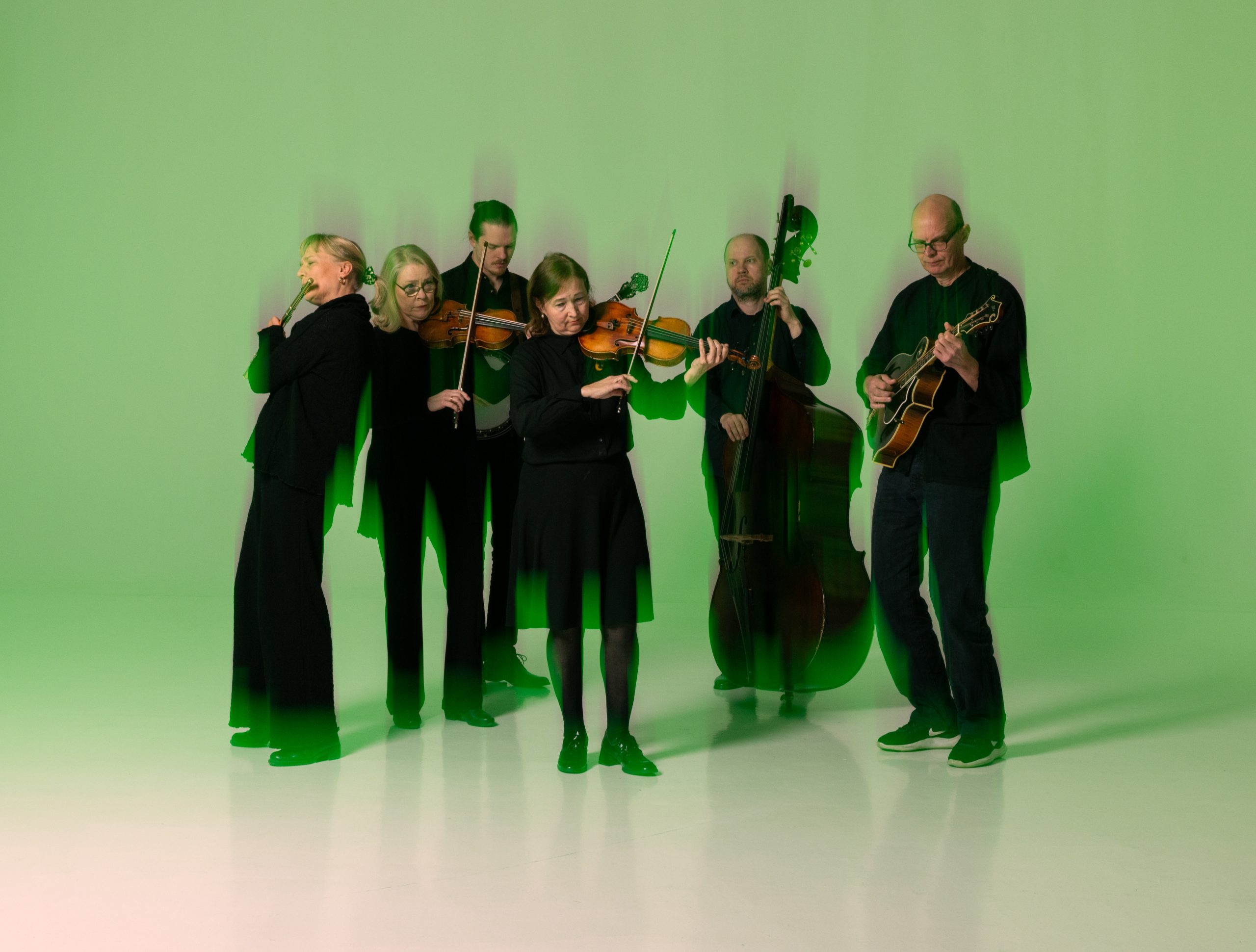 Pienkokoonpano jammailee soittimillaan, kuvassa vihreä sävy.